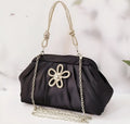Women's black shell shape crossbody bag with diamond pattern and chain details showing internal document compartment