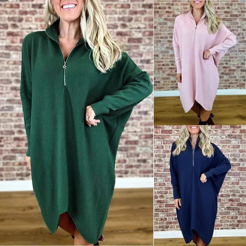 A woman wearing a solid colour loose knitted dress with raglan sleeves, shown in one of five available colours.