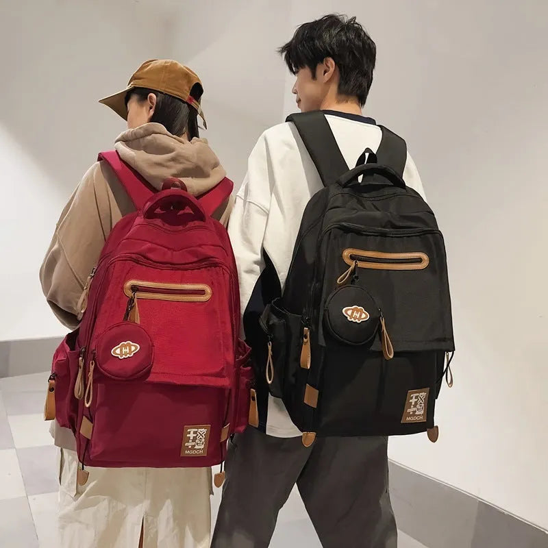 Large-capacity nylon backpack for middle school students in solid colour with curved shoulder strap and sewing line detail