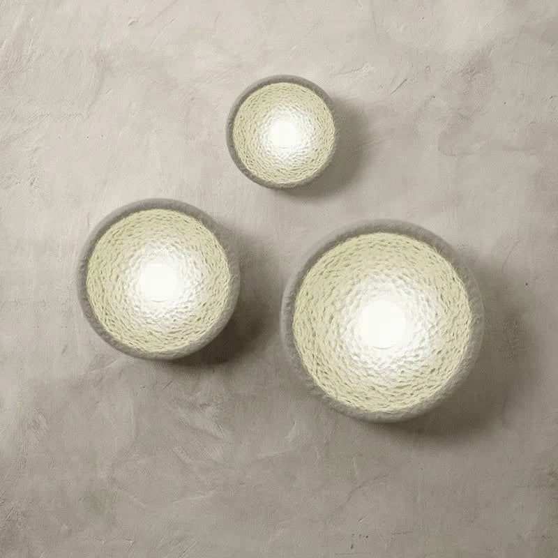 Japanese-style minimalist wall lamp with resin shade in three diameter sizes on white wall
