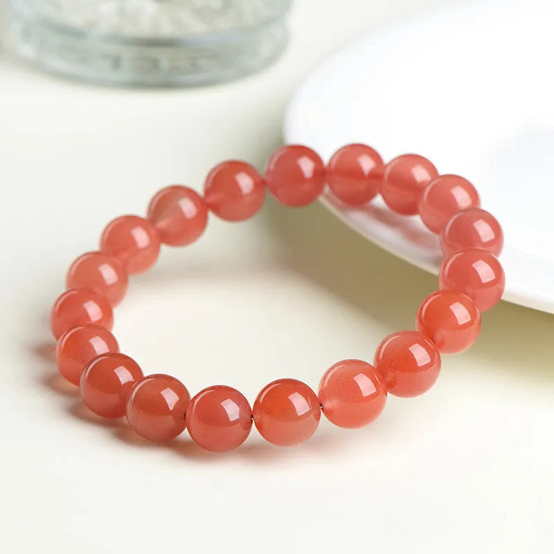 Natural South Cherry Red Agate beaded bracelet on a wrist, showing polished scattered beads on an elastic cord.