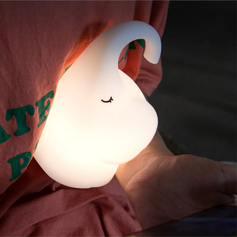 Soft silicone elephant night light with warm white LED glow on bedside table