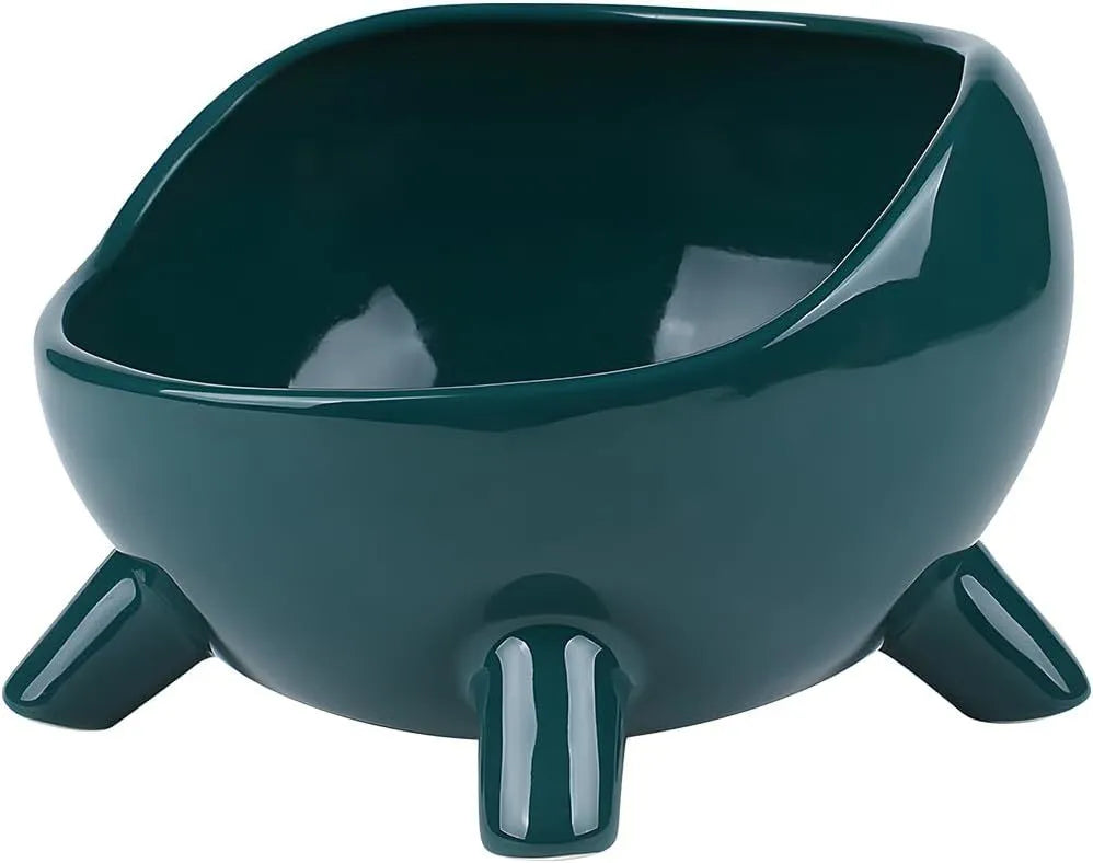 Green ceramic cat food bowl with four legs, wide mouth, and rounded arc shape on a light floor