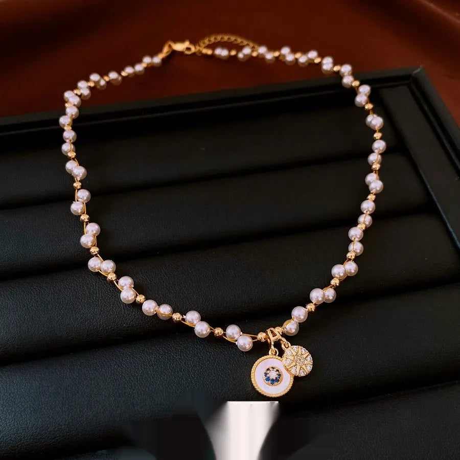 Gold electroplated pendant necklace with zircon stones and imitation pearl centre on clavicle chain