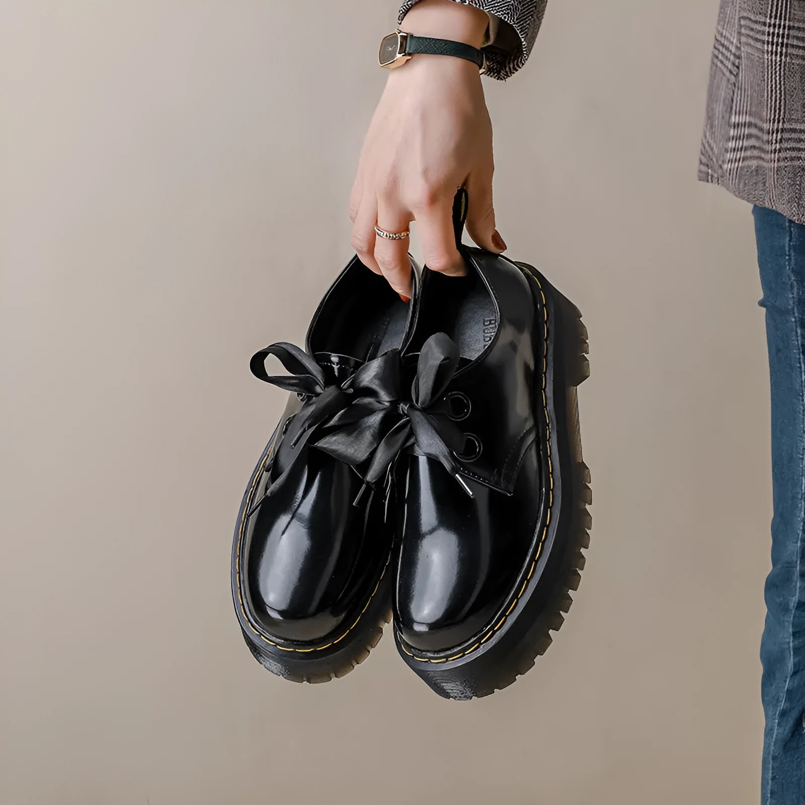 Women's white lace-up leather shoes with thick soles and black cross straps on the ankle.