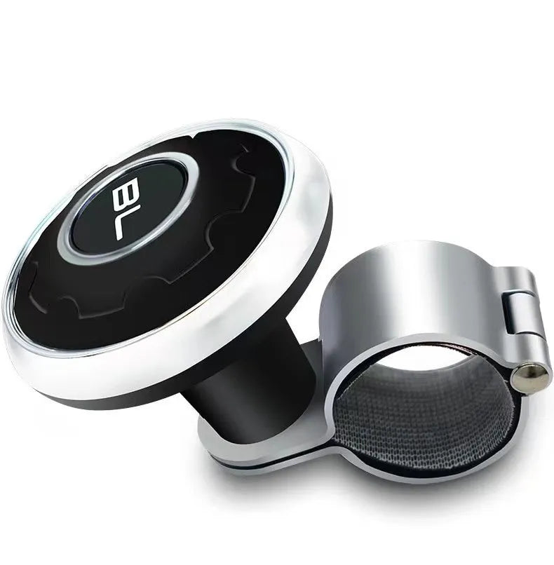 Metal universal steering wheel assist ball with steel ball bearing in silver finish mounted on a car steering wheel for one-handed control