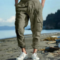 Men's loose linen trousers in Army Green with ankle ties and a multi-pocket tether detail.
