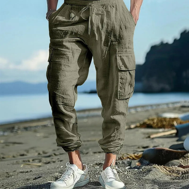 Men's loose linen trousers in Army Green with ankle ties and a multi-pocket tether detail.