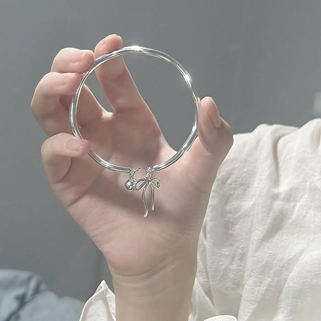 Adjustable silver bracelet with bow design and opening clasp on zinc alloy base