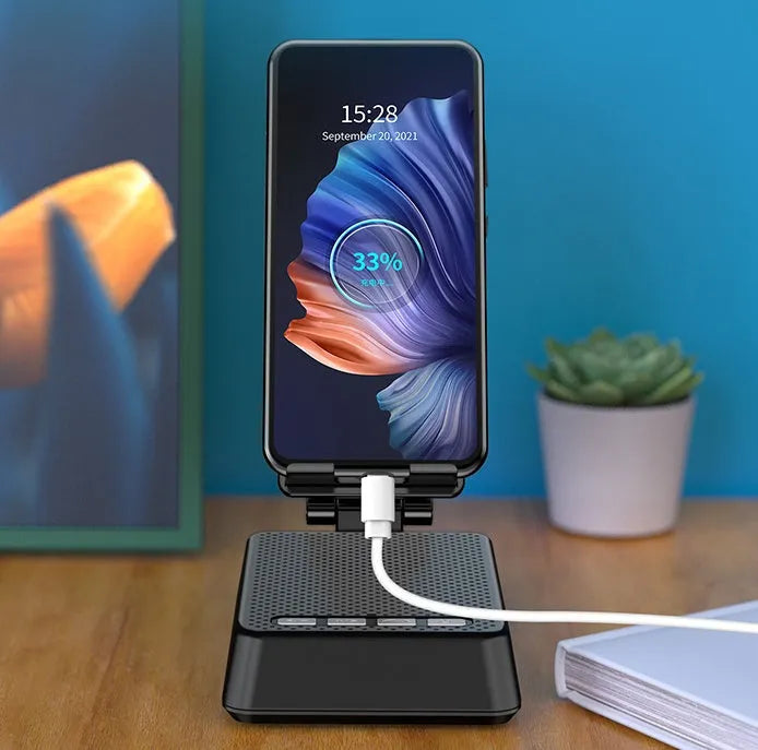 Black mobile phone broadcaster stand with Bluetooth speaker and microphone on a desk