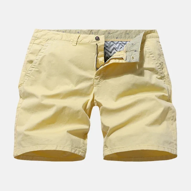 Men's loose fit printed denim shorts in blue, shown in a casual setting.