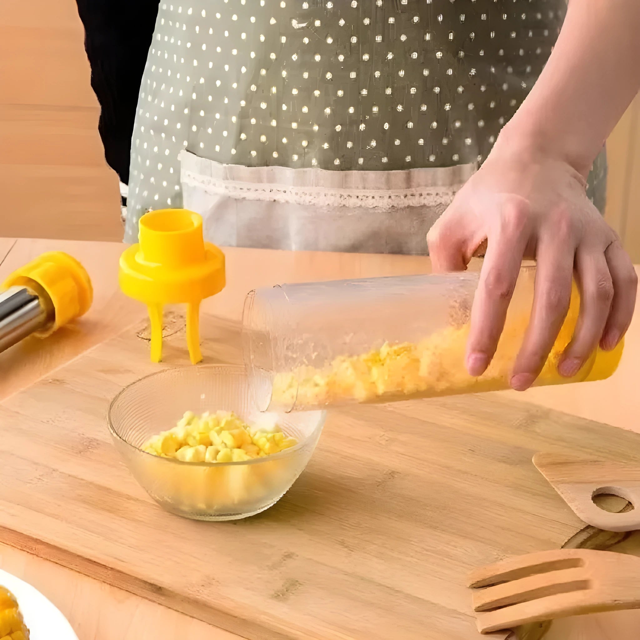 Yellow manual corn stripper with cylindrical ABS plastic body and stainless steel insert on white background