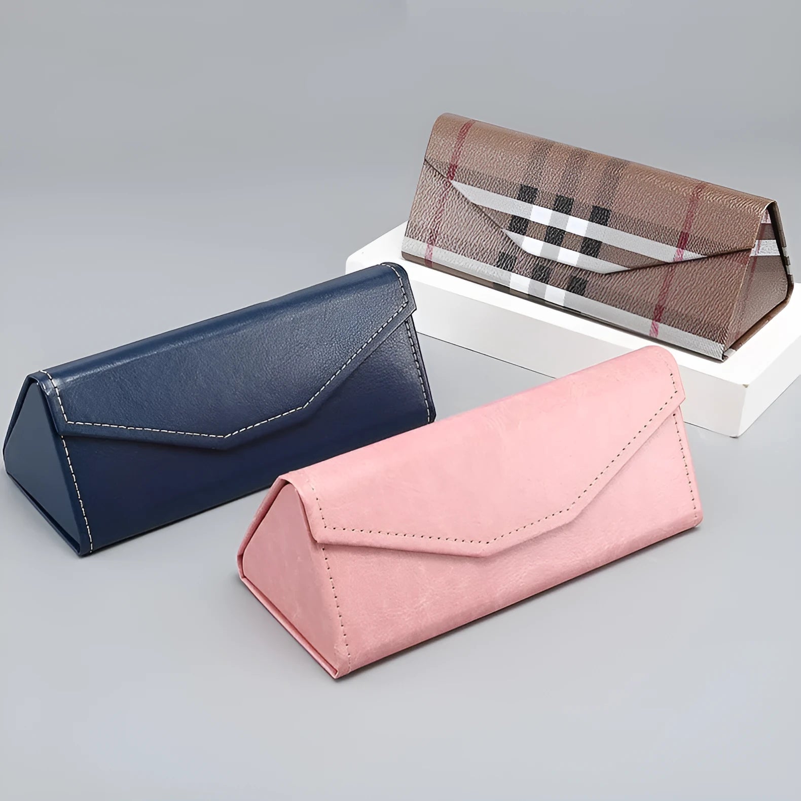 Folding glasses case in black PU cowhide with handmade stitching and triangle shape lying open