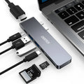 Silver aluminium USB-C 7-in-1 hub adapter with SD card, Micro SD, HDMI, USB 3.0, and Power Delivery ports.