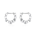A pair of sterling silver geometric earrings with round elements on a white background.
