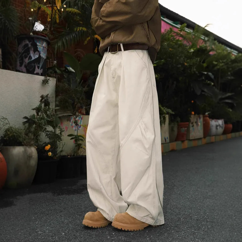 Men's pleated straight leg loose fit trousers in a black stripe pattern, showing front and side details.