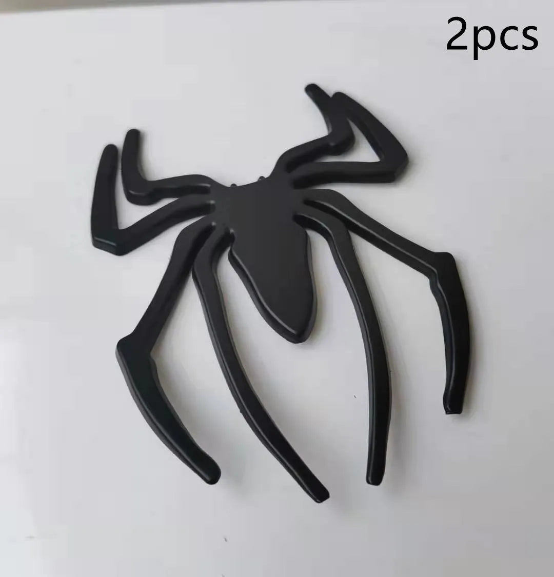 Three-dimensional metal spider bumper sticker in silver finish, measuring 7cm by 5cm.