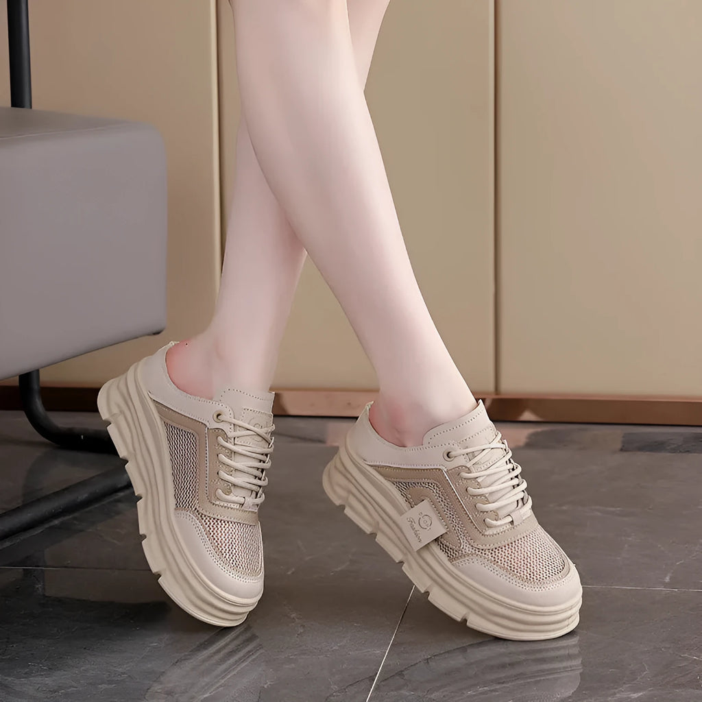 Women's black mesh half slippers with round toe and rubber sole, shown on a foot.
