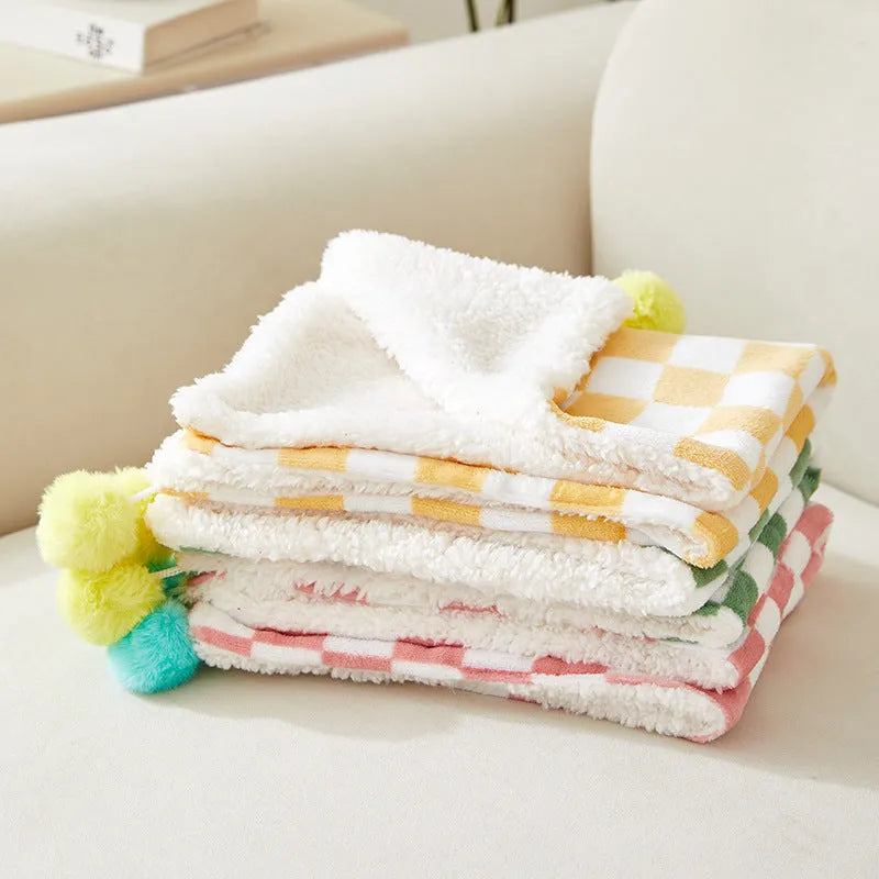 Plush pet blanket with plaid pattern and fur ball decoration for cats and dogs