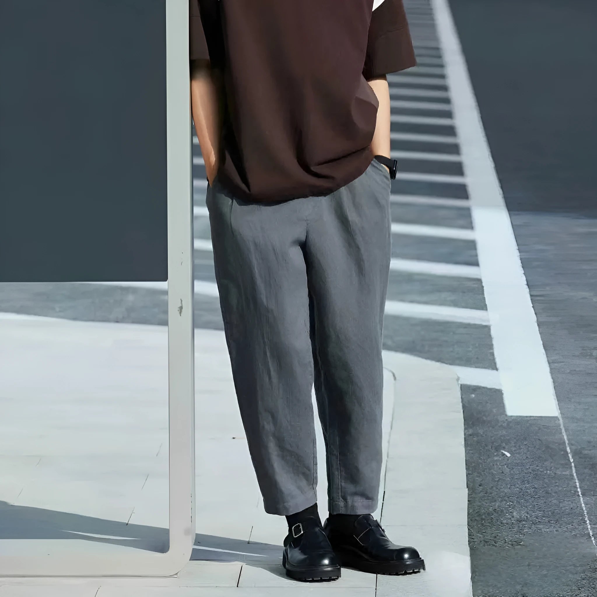 Man wearing beige loose straight casual trousers with a drawstring waistband.