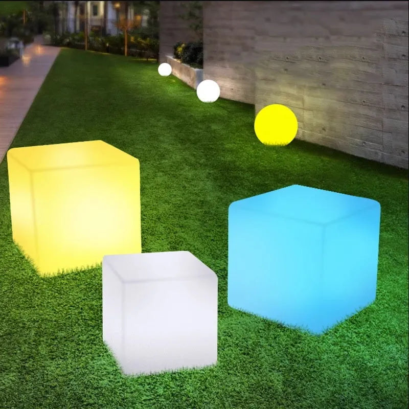 Modern LED illuminated cube stool in outdoor garden setting showing waterproof construction and integrated lighting