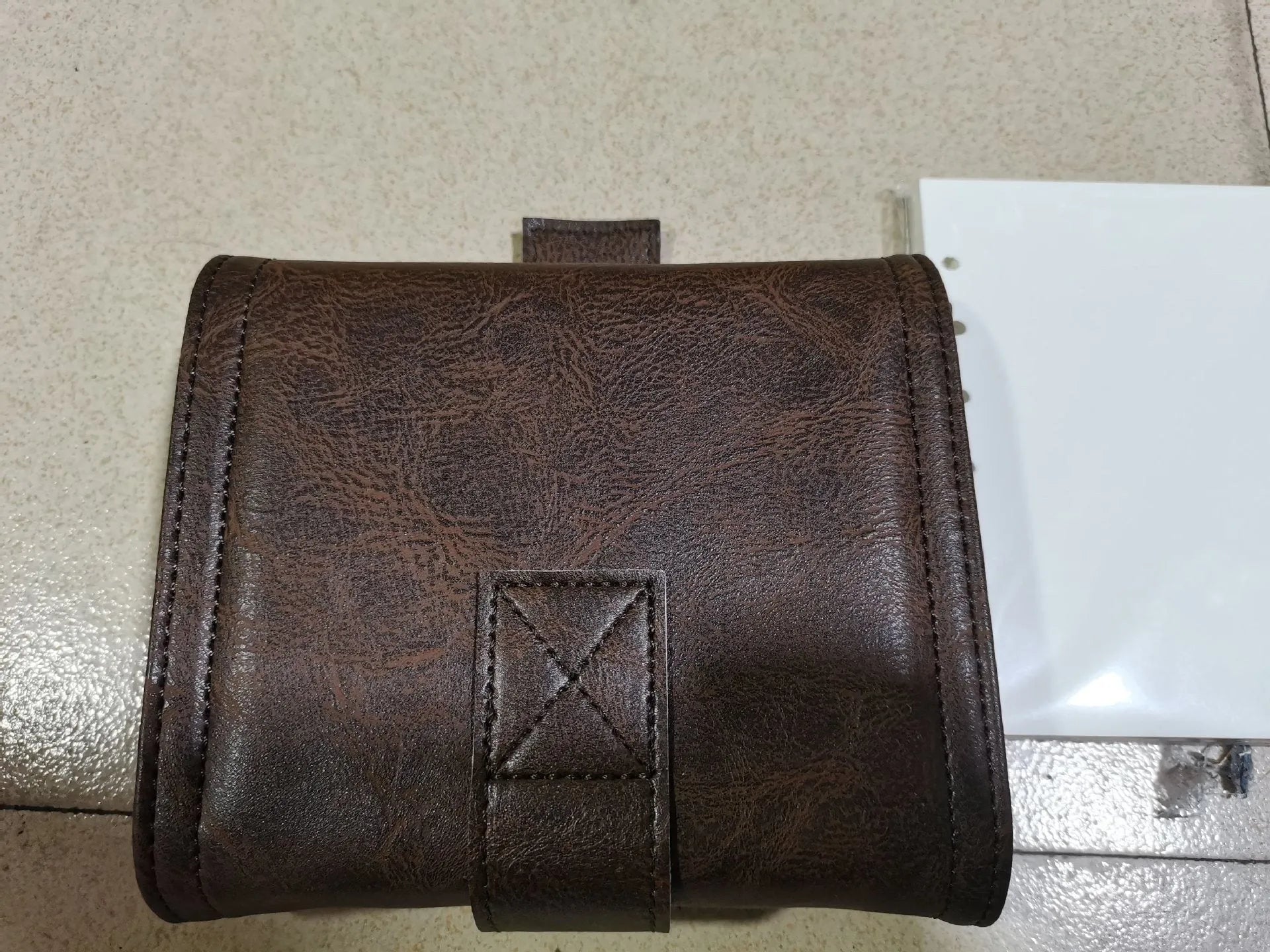 Brown A7 notebook with retro leather buckle closure showing loose-leaf binding