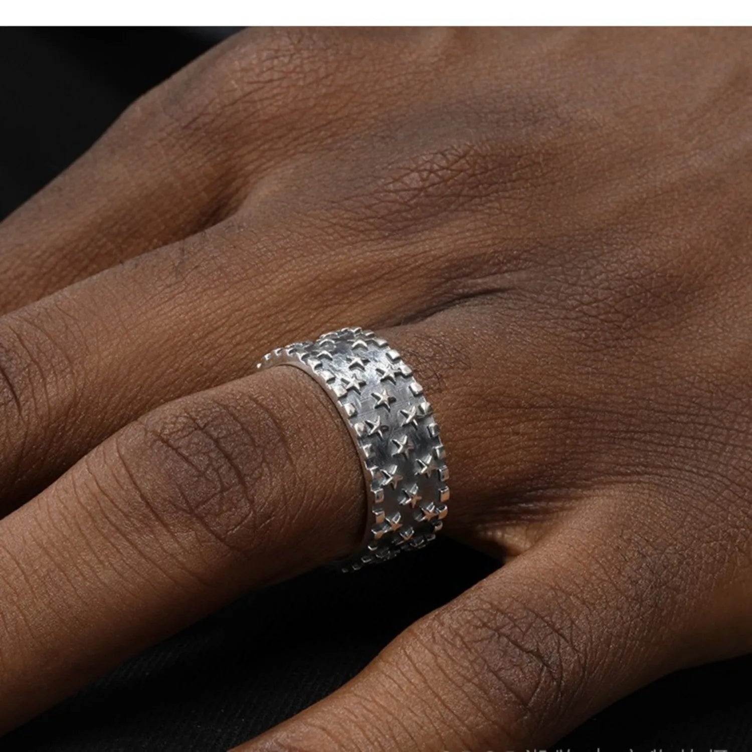Adjustable sterling silver ring with a raised five-pointed star design on the band.