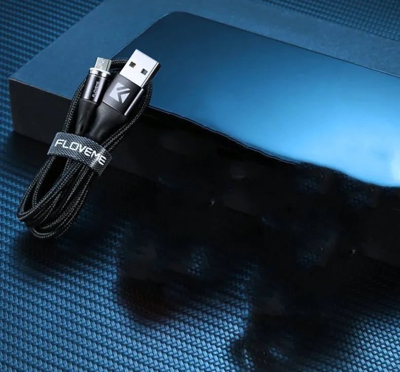 Black magnetic data cable with USB-C connector and side LED light, laid flat next to its aluminium foil packaging.