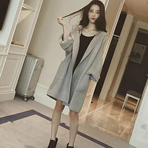 Plus size woman wearing a loose-fitting thin gray coat with long sleeves and lace detail.