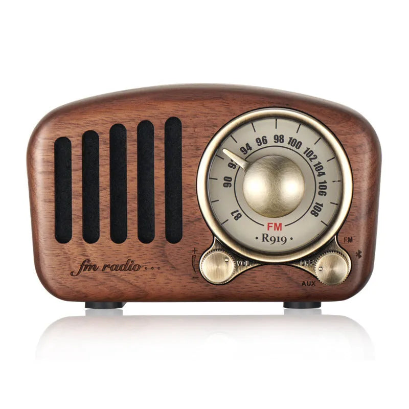 Retro wooden wireless mini speaker in cherry wood finish on a wooden table.