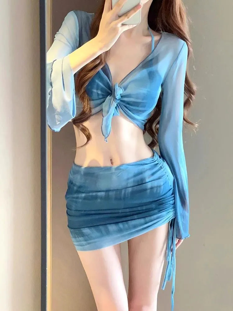 Women's blue high-waist bikini set with shirt, bra, underwear, and skirt laid flat.