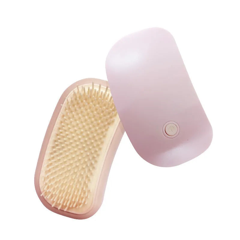 Pink handheld electric pet brush with TPE comb teeth for grooming cats and dogs.