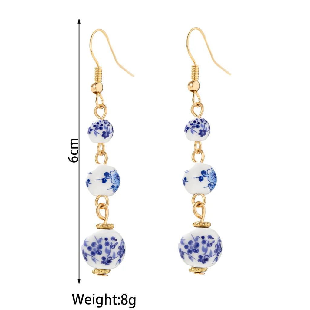 Blue and white porcelain ceramic beads long drop earrings on display with geometric round shape and alloy backing