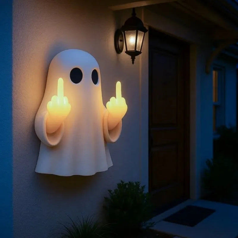 White plastic ghost night lamp with light on, on a flat surface