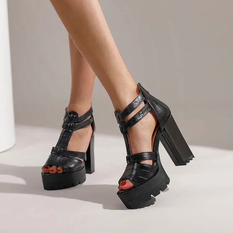 Black platform high heel sandals with round head and back zipper on plain background