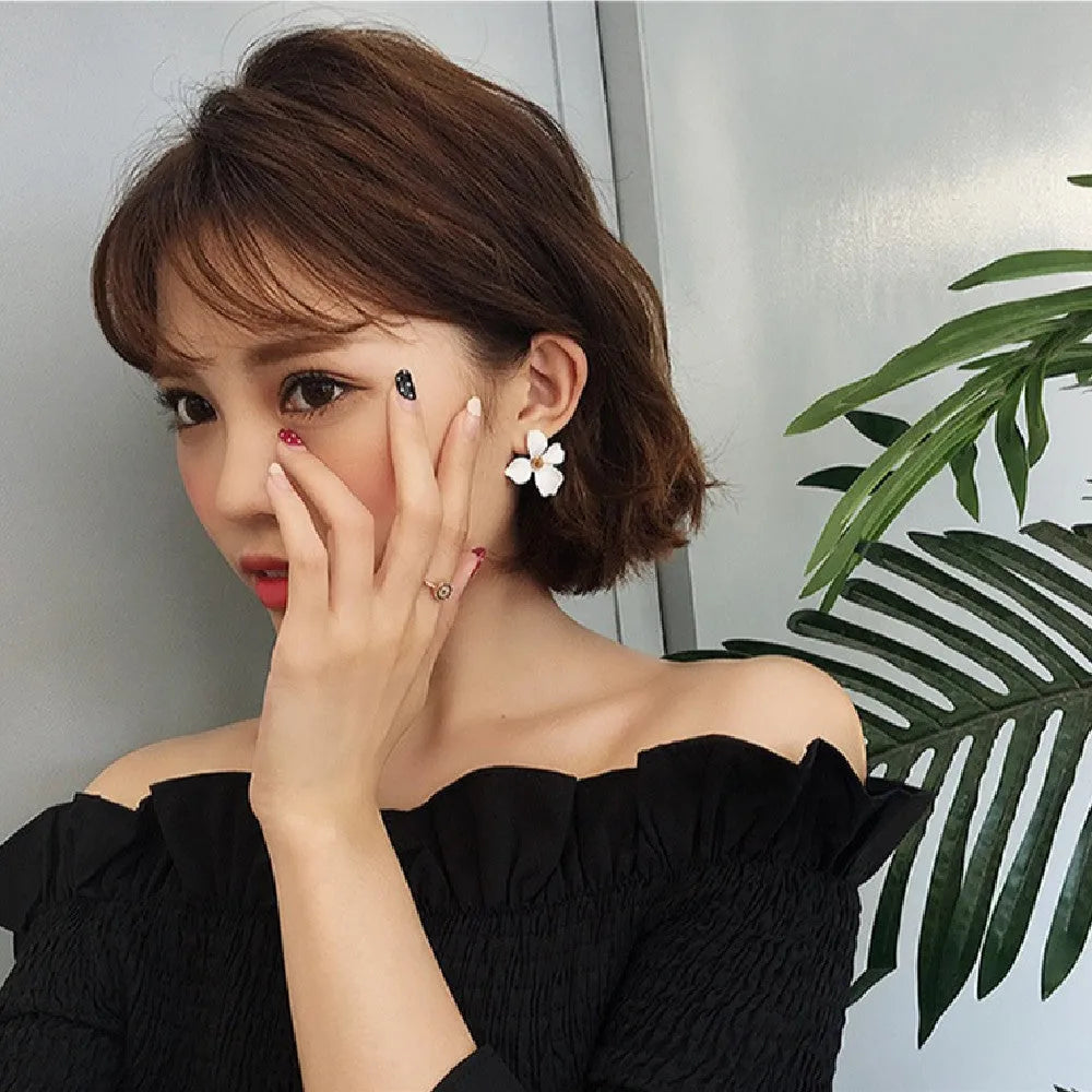 Flower-shaped alloy stud earrings with electroplated pink or white finish and clutch backings