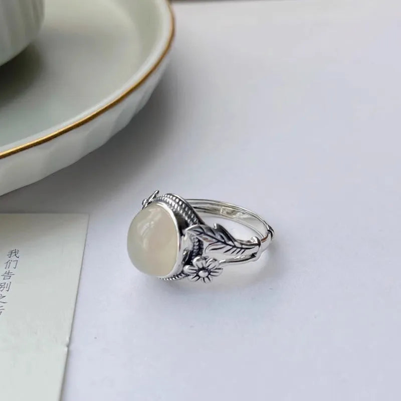 Copper vintage ring with imitation white chalcedony stone and adjustable U-shaped open design.
