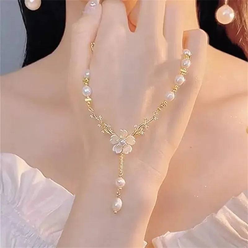 Women's alloy necklace with a white pearl flower and rose design pendant on a chain.
