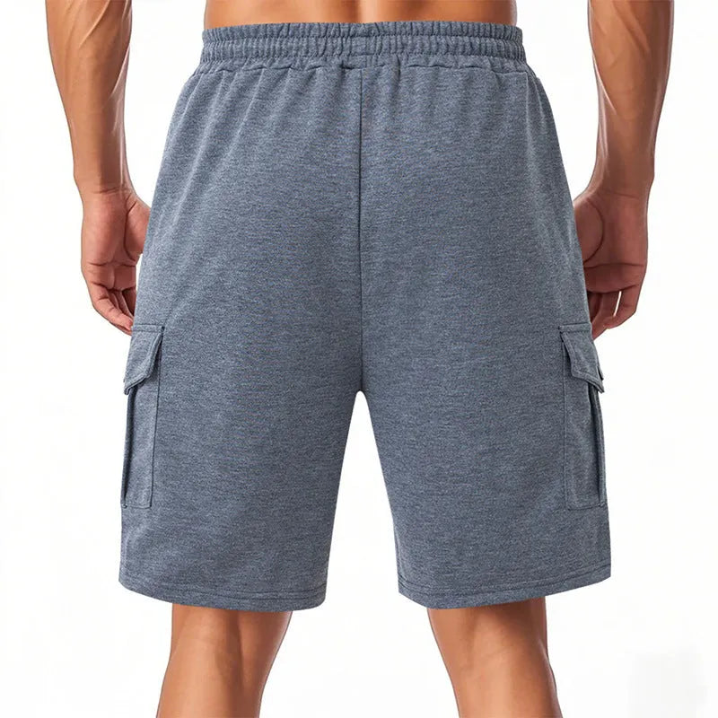 Men's light grey loose-fit terry cotton cargo shorts with multiple pockets on a plain background.