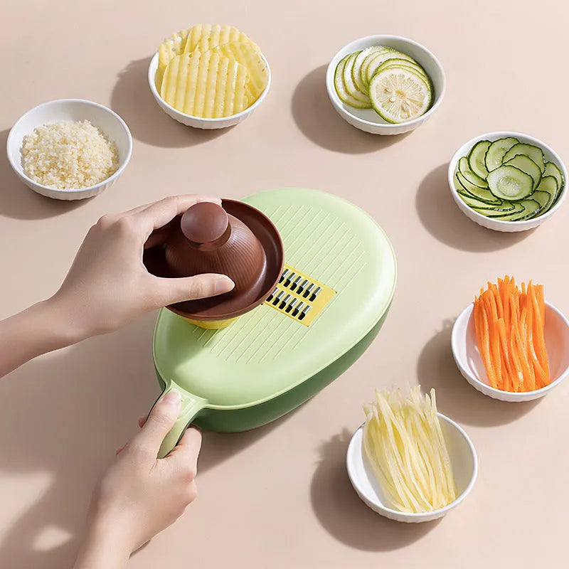 Vegetable grater slicer with six sabres and bottom storage box in avocado green colour on a kitchen counter