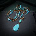 Long blue turquoise imitation mineral pendant necklace with a geometric setting on a ball bead chain.