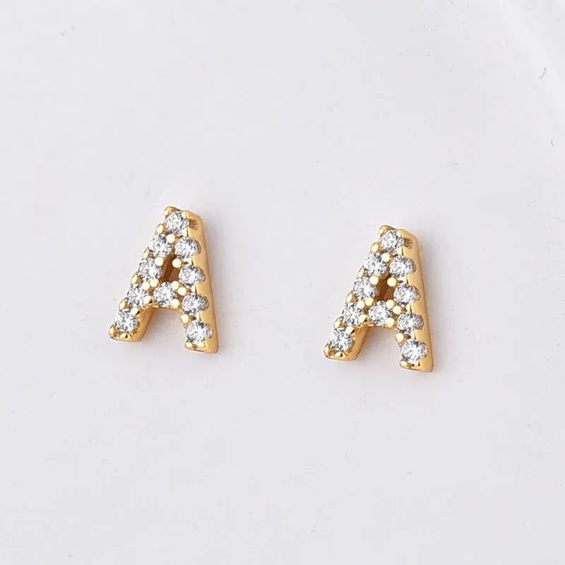 Gold plated alphabet letter earrings on a white background showing the letter A with zircon stones and butterfly backings.