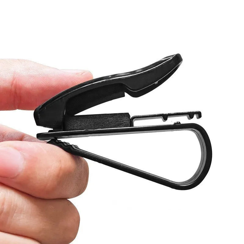 Black plastic multifunctional clip for car sun visors, designed to hold sunglasses and cards.