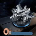Silver solar powered rotating fighter jet perfume ornament on a beech wood base.