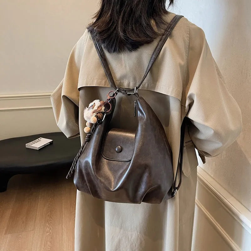 Black PU leather women's single strap shoulder bag showing horizontal square shape and internal mobile phone compartment