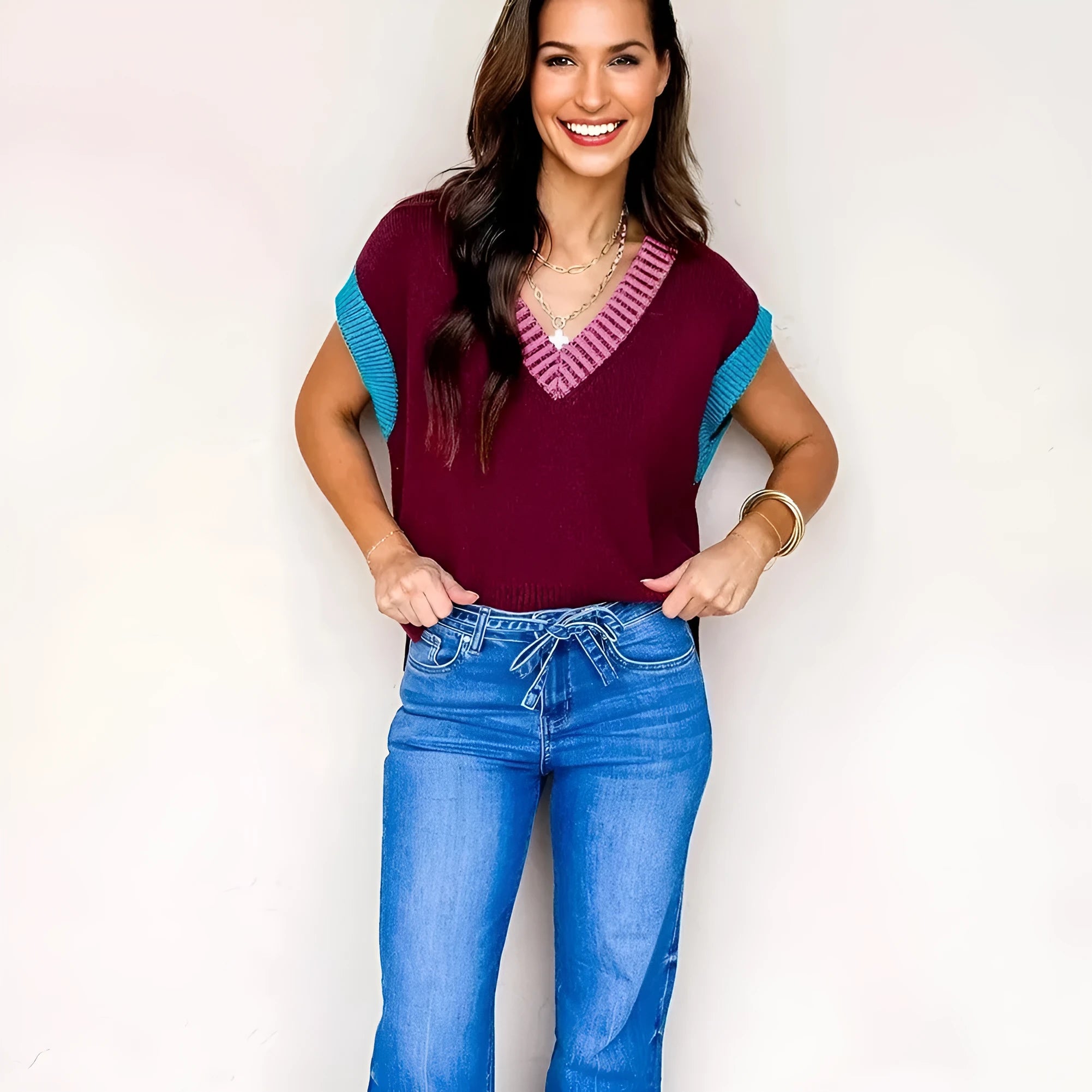 Burgundy women's loose V-neck sweater with contrast trim on short cuffed sleeves.