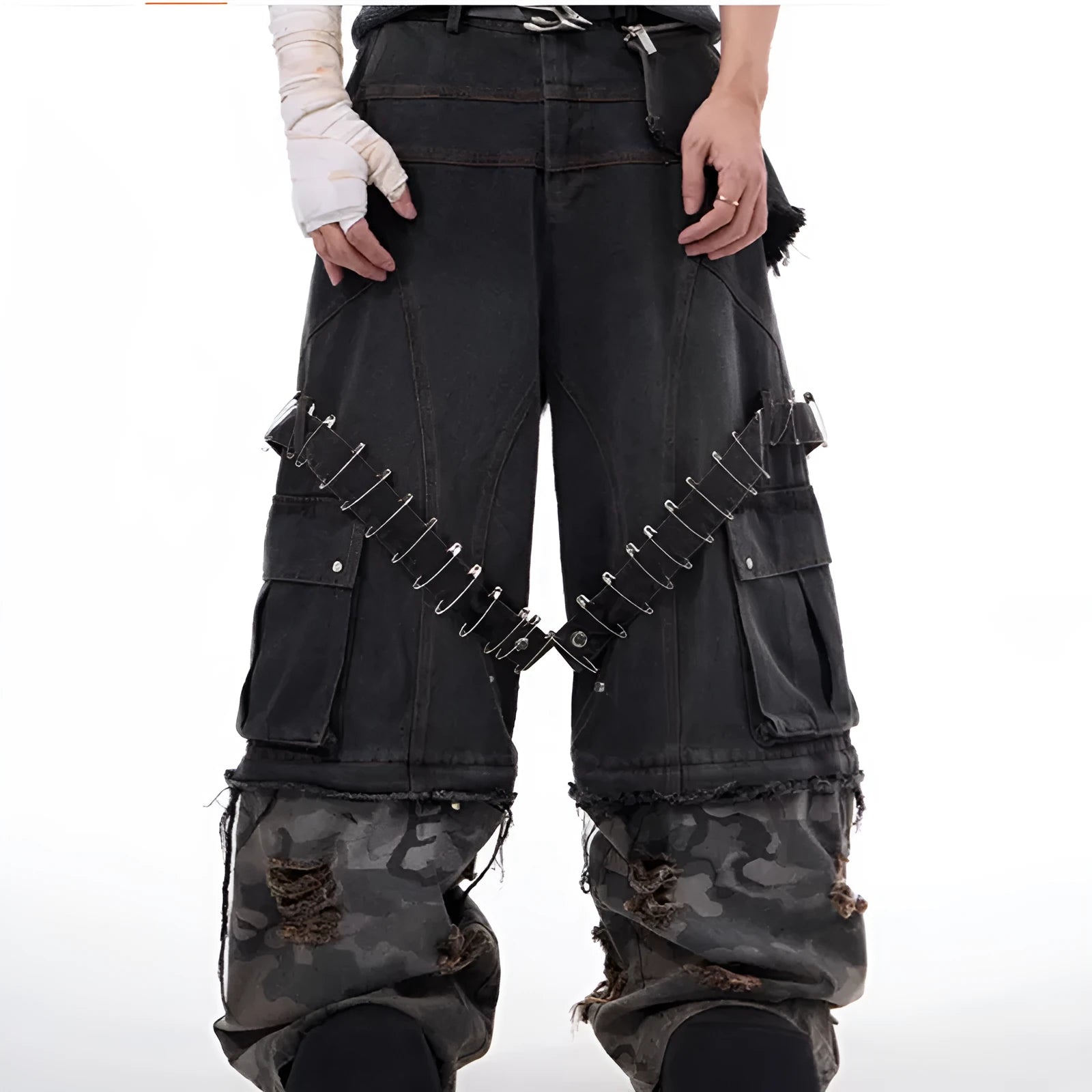 Men's grey cotton jeans with camouflage pattern splicing and decorative pin and ribbon details on the legs.