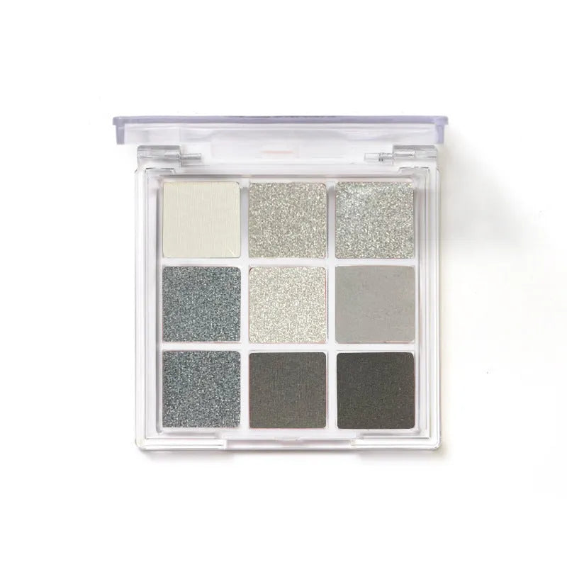 Nine-colour smoked eye shadow palette showing pressed powder shades including white, silver, black, and grey.