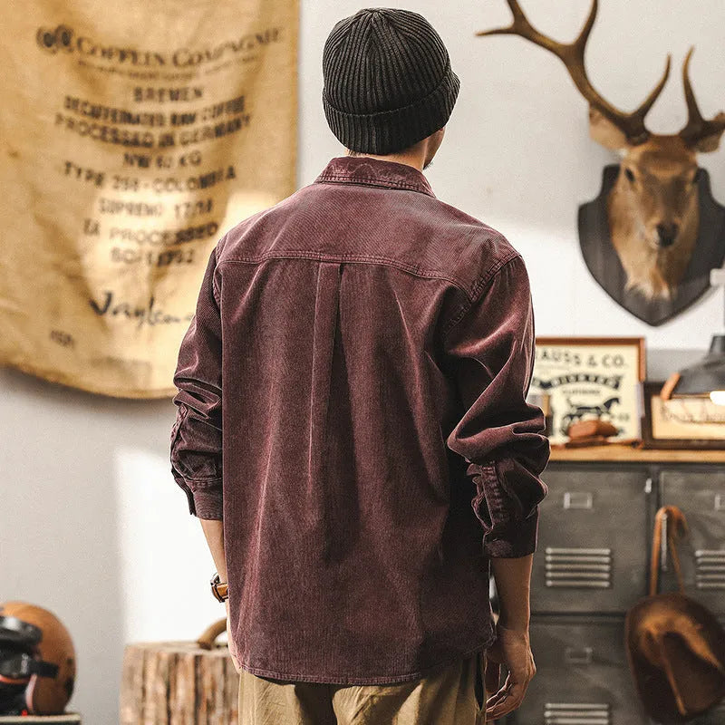 Man wearing a loose-fitting red corduroy shirt jacket with long sleeves.
