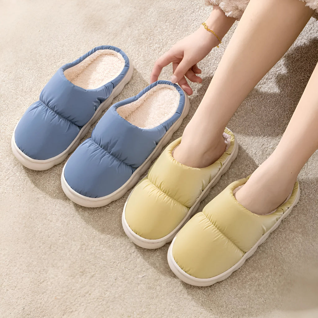 Blue winter house slippers with artificial leather upper, thick rubber sole, and plush lining on a wooden floor.